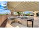 An outdoor kitchen is fully equipped, featuring a grill, sink, mini-fridge, and ample counter space perfect for entertaining at 5949 Casa Coronado Ave, Las Vegas, NV 89131