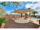 View of backyard with outdoor kitchen, pergola, waterfall feature, brick wall, and desert landscaping at 5949 Casa Coronado Ave, Las Vegas, NV 89131