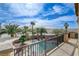 Balcony view of a backyard featuring a sparkling pool and spa, surrounded by mature palm trees at 5949 Casa Coronado Ave, Las Vegas, NV 89131
