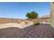 Landscaped backyard with multiple design elements, stone accents, and desert surroundings at 6088 Gulf Island Ave, Las Vegas, NV 89156
