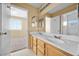 Bathroom featuring a double vanity, a mirror, and a view into the bedroom at 6088 Gulf Island Ave, Las Vegas, NV 89156