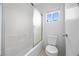 Bathroom featuring a shower with glass doors, a toilet and a window at 6088 Gulf Island Ave, Las Vegas, NV 89156