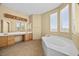 Bright bathroom with a soaking tub, a large vanity, and tile flooring at 6088 Gulf Island Ave, Las Vegas, NV 89156