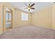 Spacious bedroom with plush carpet, a ceiling fan, and a view into the bathroom at 6088 Gulf Island Ave, Las Vegas, NV 89156