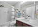 Clean bathroom featuring white vanity, tiled shower with curtain, and bright overhead lighting at 6141 Annville Ct, North Las Vegas, NV 89081