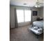This is a well-lit bedroom featuring carpet flooring, neutral walls, and a ceiling fan at 6141 Annville Ct, North Las Vegas, NV 89081