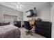 Bedroom featuring a window, ceiling fan, television, with dark wooden furniture and carpet at 6141 Annville Ct, North Las Vegas, NV 89081