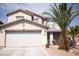 Home exterior featuring a two-car garage and well-kept xeriscaped front yard with palm trees at 6141 Annville Ct, North Las Vegas, NV 89081