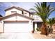Two-story home with a two car garage, palm trees, and desert landscaping at 6141 Annville Ct, North Las Vegas, NV 89081
