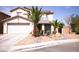 Two-story home with a two car garage, palm trees, and rock landscaping at 6141 Annville Ct, North Las Vegas, NV 89081
