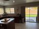 Kitchen featuring dark cabinetry, an island, access to the back yard, and tile flooring at 6141 Annville Ct, North Las Vegas, NV 89081