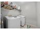 Well-lit laundry room featuring a white washer and dryer set, with shelving above for storage at 6141 Annville Ct, North Las Vegas, NV 89081