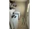 Efficient laundry room features a modern washer and dryer with overhead shelving at 6141 Annville Ct, North Las Vegas, NV 89081