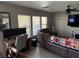 Comfortable living room featuring tiled floors, a ceiling fan, and a large tv at 6141 Annville Ct, North Las Vegas, NV 89081