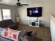 Living room featuring tile flooring, neutral walls, lots of natural light, a ceiling fan, and a wall mounted television at 6141 Annville Ct, North Las Vegas, NV 89081