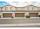 Three attached garages offer ample parking and storage with neatly kept front yard landscaping at 6228 Haiku Stairs St, Las Vegas, NV 89148