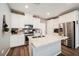 Bright kitchen featuring white cabinets, granite countertops, stainless steel appliances, and a stylish brick backsplash at 6228 Haiku Stairs St, Las Vegas, NV 89148