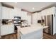Beautiful kitchen features white cabinetry, stainless steel appliances, an island, and brick-style backsplash at 6228 Haiku Stairs St, Las Vegas, NV 89148