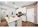 Open concept kitchen with island, stainless steel appliances, white cabinets and brick wall at 6228 Haiku Stairs St, Las Vegas, NV 89148