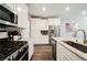 Bright kitchen showcasing stainless steel appliances, an island with a sink, and a brick-style backsplash at 6228 Haiku Stairs St, Las Vegas, NV 89148