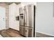 Modern kitchen with stainless steel fridge, white cabinets, brick wall, and wood grain flooring at 6228 Haiku Stairs St, Las Vegas, NV 89148