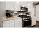 Modern kitchen featuring stainless steel appliances, white cabinetry, and granite countertops with a brick backsplash at 6228 Haiku Stairs St, Las Vegas, NV 89148