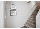 Carpeted staircase leading to upper level with neutral walls and decorative artwork at 6228 Haiku Stairs St, Las Vegas, NV 89148