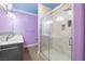 Bathroom featuring a glass-enclosed shower, double sink vanity, marble tile, and modern fixtures at 6655 Flaminian Ln # 104, North Las Vegas, NV 89084