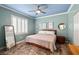 A primary bedroom featuring hardwood floors, a ceiling fan, and a large mirror at 6655 Flaminian Ln # 104, North Las Vegas, NV 89084