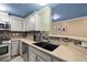 This kitchen features neutral cabinets, granite countertops, mosaic backsplash, and stainless steel appliances at 6655 Flaminian Ln # 104, North Las Vegas, NV 89084