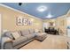 Spacious living room featuring a large gray sofa, modern decor, and open layout at 6655 Flaminian Ln # 104, North Las Vegas, NV 89084
