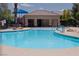 Community pool featuring a splash pad, lounge seating, shade structures, and lush landscaping at 6655 Flaminian Ln # 104, North Las Vegas, NV 89084
