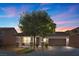 Charming two-story home with a well-manicured front yard and inviting front porch at dusk at 6857 Stone Tower Ct, Las Vegas, NV 89149