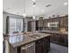 Spacious kitchen with dark cabinets, granite countertops, a large island and stainless steel appliances at 6857 Stone Tower Ct, Las Vegas, NV 89149
