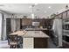 Gourmet kitchen features stainless steel appliances, dark cabinets, tile floors and granite countertops with island at 6857 Stone Tower Ct, Las Vegas, NV 89149