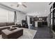 Bright living space showcasing sectional, massage chair, dark floors, and easy kitchen access at 6857 Stone Tower Ct, Las Vegas, NV 89149