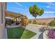 Fully landscaped backyard with covered patio, playhouse, and mature trees at 7112 Rancho De Taos Ct, Las Vegas, NV 89130
