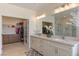 Bathroom showcasing double vanity, mirrors, shower, and walk-in closet at 7112 Rancho De Taos Ct, Las Vegas, NV 89130