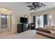 Spacious living room with large television, decorative ceiling fan, and adjacent bathroom at 7112 Rancho De Taos Ct, Las Vegas, NV 89130