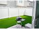 Backyard featuring artificial grass, patio, BBQ grill, and a white fence at 7342 N Decatur Blvd # 5, Las Vegas, NV 89131
