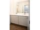 Bathroom with double sink vanity, white cabinets, wood-look floors, and large mirror at 7342 N Decatur Blvd # 5, Las Vegas, NV 89131
