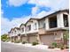 View of townhome exteriors with garages and desert landscaping on a sunny day at 7342 N Decatur Blvd # 5, Las Vegas, NV 89131