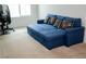 Comfortable living space features a blue sectional sofa with storage, soft carpet, and a large window at 7342 N Decatur Blvd # 5, Las Vegas, NV 89131