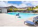 Community pool with lounge chairs, tables, shade structures, and residential buildings at 7342 N Decatur Blvd # 5, Las Vegas, NV 89131