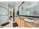 Bright bathroom featuring double sinks, granite countertop, and glass door shower at 7404 Eggshell Dr, North Las Vegas, NV 89084