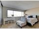 Bright bedroom features a large window, vanity, seating area, and comfortable bed with decorative pillows at 745 N Royal Crest Cir # 127, Las Vegas, NV 89169
