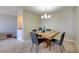 Bright dining room with a modern light fixture, carpeted floors, and a rustic wooden dining table at 745 N Royal Crest Cir # 127, Las Vegas, NV 89169