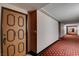 Hallway leading to Unit 127 with patterned carpet and door at 745 N Royal Crest Cir # 127, Las Vegas, NV 89169