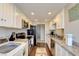 Galley kitchen featuring granite countertops, a black refrigerator, a stainless-steel sink, and dark wood flooring at 745 N Royal Crest Cir # 127, Las Vegas, NV 89169