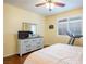 Bedroom featuring a ceiling fan, hardwood floors, plantation shutters and a dresser with mirror at 7611 Redcloud Peak St St, Las Vegas, NV 89166